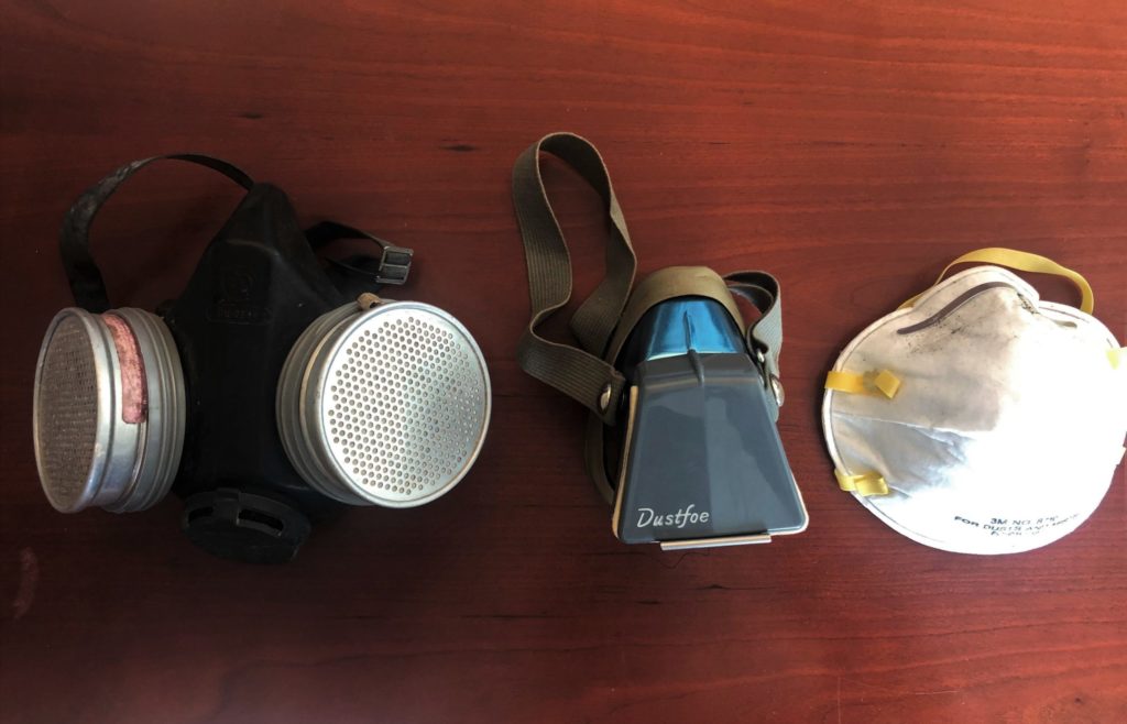 Photo of 3 respirators; one with aluminum encased filters; a Dustfoe, and a paper nose cone