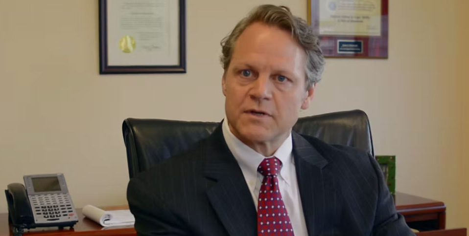 Photograph of Attorney Andrew Wainwright sitting at his desk.