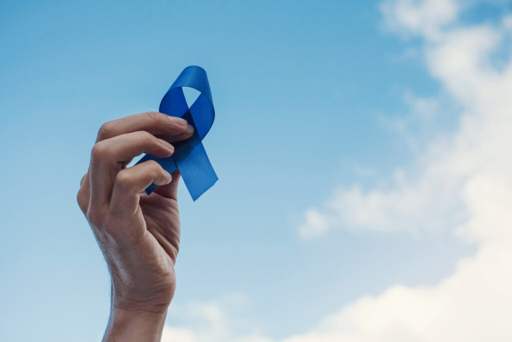 Blue ribbon held in air against a blue sky